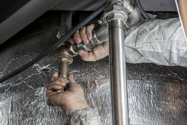 Plumber installing copper pipes by hand