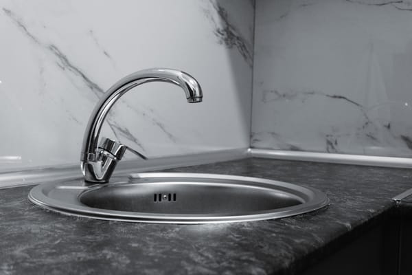 Stainless steel kitchen sink with a chrome tap